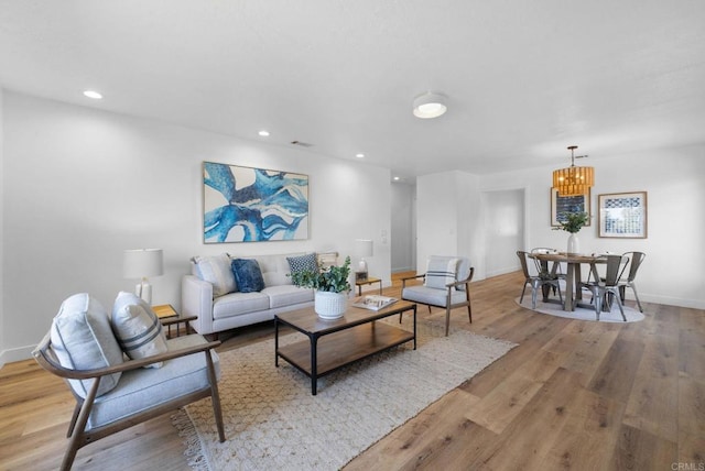 living area featuring a chandelier, recessed lighting, light wood-style flooring, and baseboards