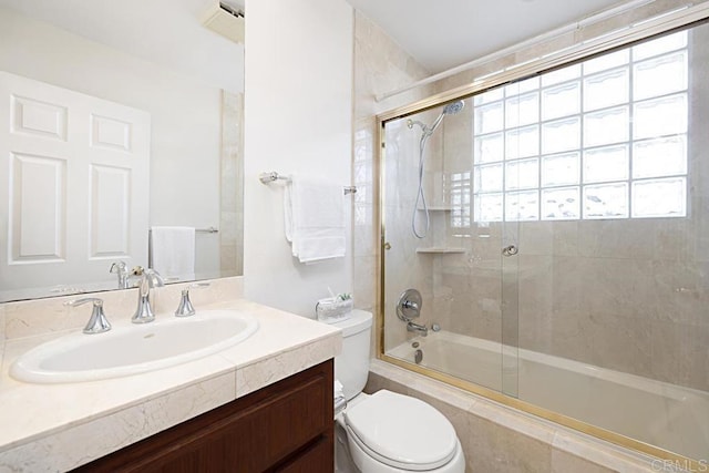 full bathroom with vanity, shower / bath combination with glass door, and toilet