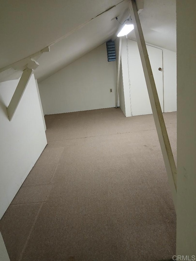 additional living space featuring lofted ceiling and light carpet