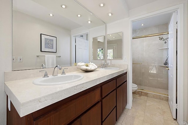 bathroom featuring a shower with door, vanity, and toilet