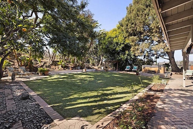 view of yard featuring a hot tub and a patio