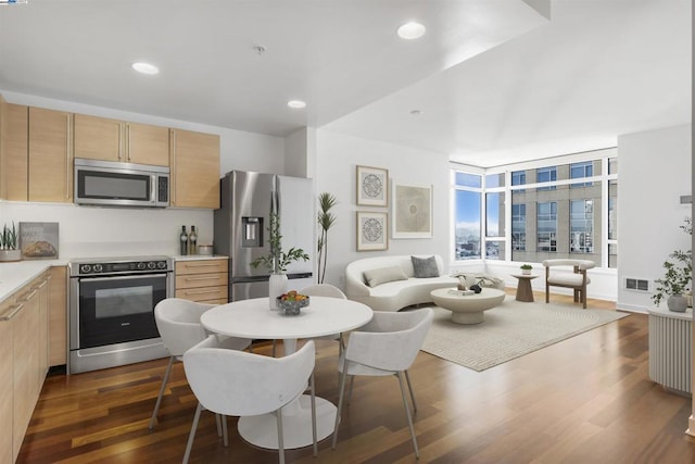 kitchen featuring stainless steel appliances, dark hardwood / wood-style flooring, and light brown cabinetry