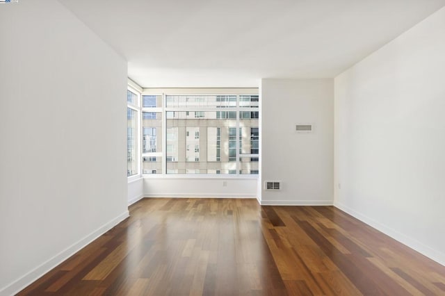 unfurnished room with dark hardwood / wood-style flooring