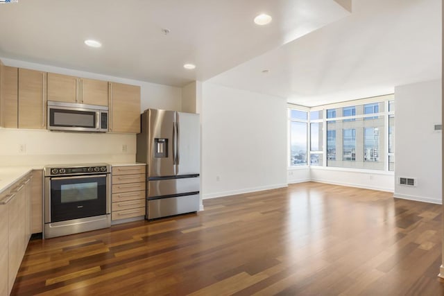 kitchen with appliances with stainless steel finishes, dark hardwood / wood-style flooring, and light brown cabinets