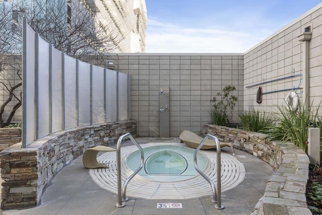 view of patio / terrace with an in ground hot tub