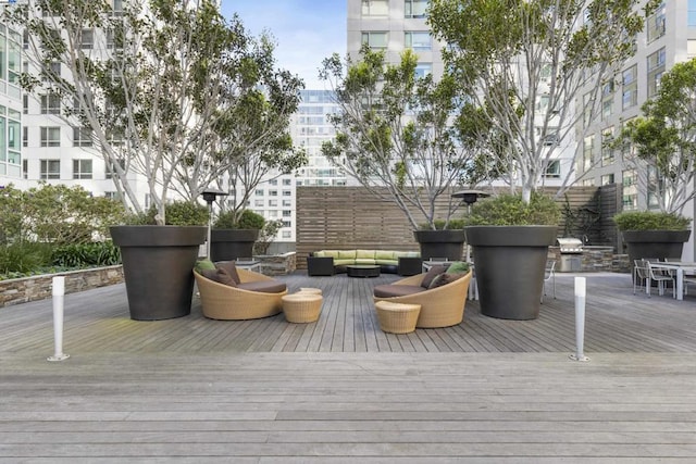 wooden terrace with an outdoor hangout area and grilling area