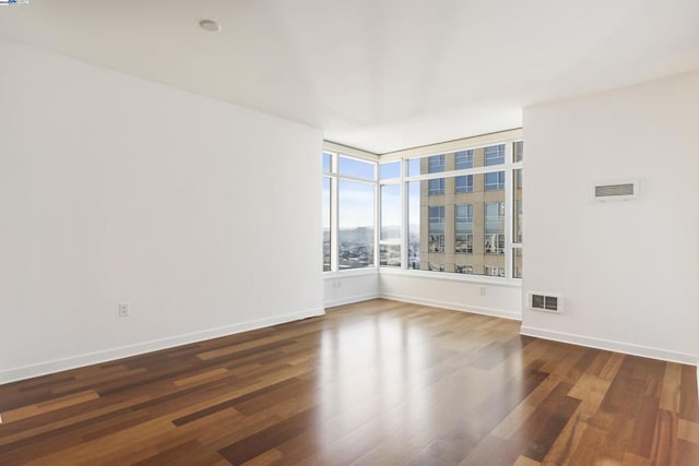 empty room with dark hardwood / wood-style flooring