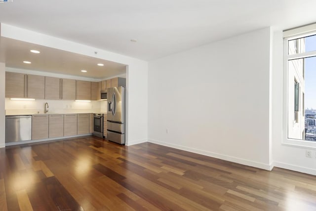 kitchen featuring stainless steel appliances, sink, light brown cabinets, and dark hardwood / wood-style floors