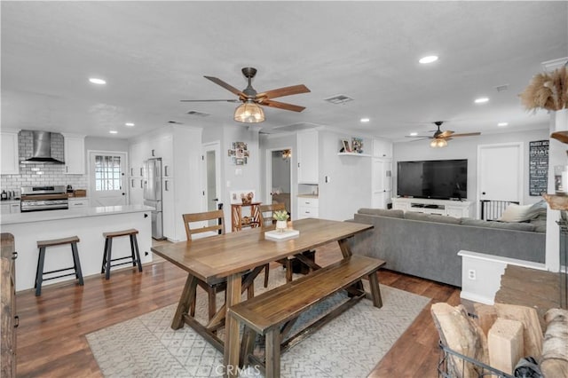 dining space with ceiling fan and light wood-type flooring