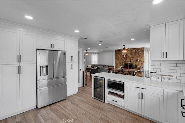 kitchen with white cabinets, appliances with stainless steel finishes, wine cooler, and ceiling fan