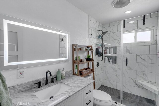 bathroom featuring vanity, an enclosed shower, and toilet