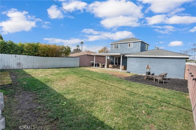 rear view of property featuring a yard and a patio area