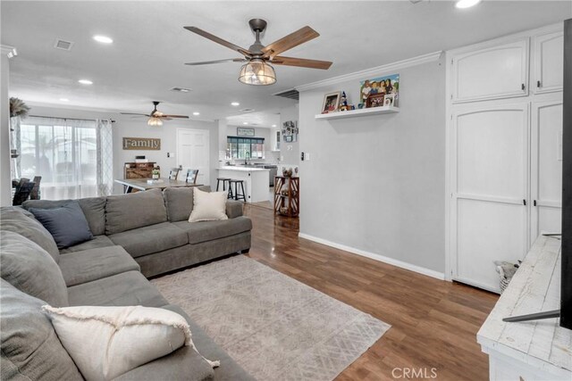 living room featuring ornamental molding, sink, ceiling fan, and light hardwood / wood-style flooring