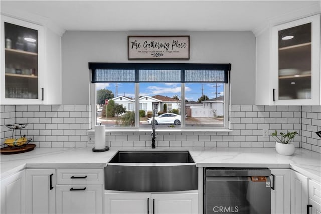 kitchen with white cabinetry, decorative backsplash, sink, and light stone counters