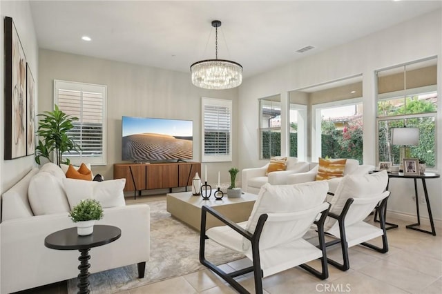 living room featuring a healthy amount of sunlight, light tile patterned floors, and a chandelier