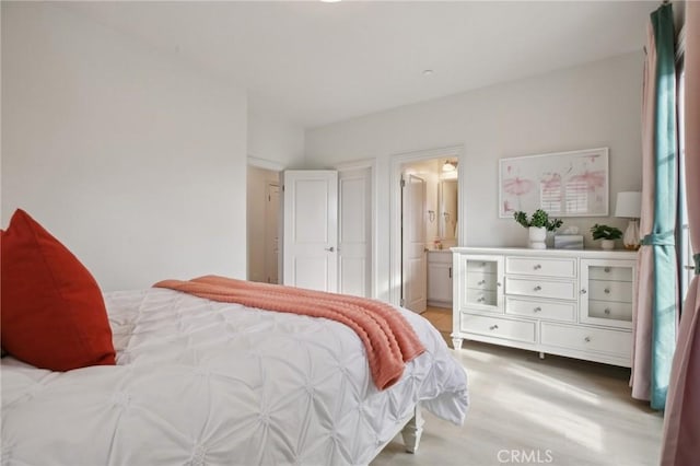 bedroom with light hardwood / wood-style flooring and ensuite bathroom