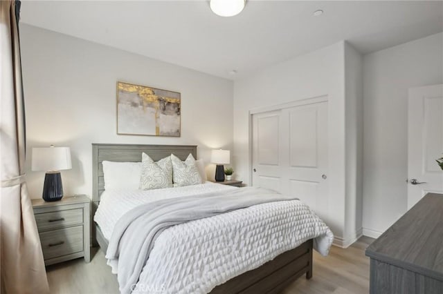 bedroom with light hardwood / wood-style flooring and a closet