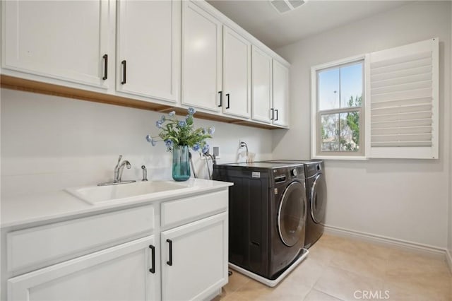 washroom featuring cabinets, light tile patterned flooring, separate washer and dryer, and sink