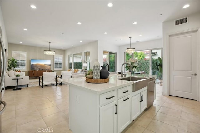 kitchen featuring pendant lighting, sink, stainless steel dishwasher, and an island with sink