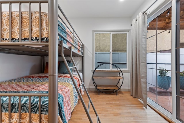 bedroom with multiple windows and wood-type flooring