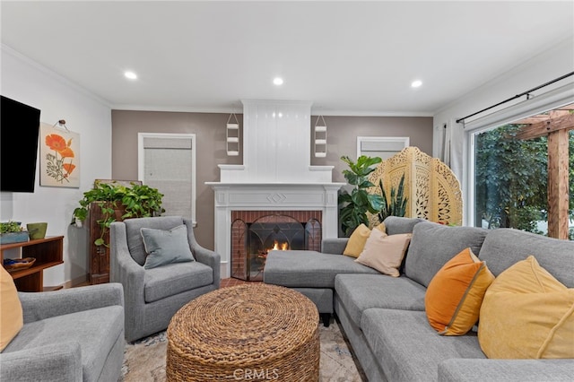 living room with crown molding, light hardwood / wood-style floors, and a brick fireplace