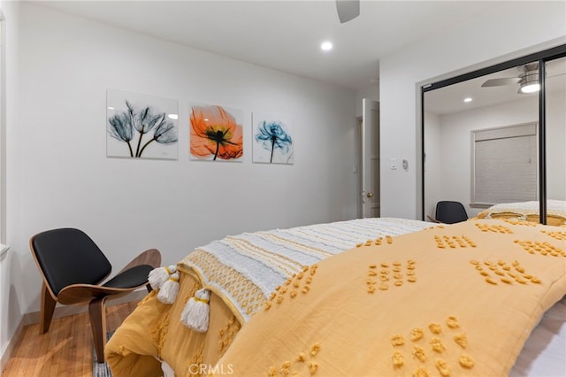 bedroom with ceiling fan, wood-type flooring, and a closet