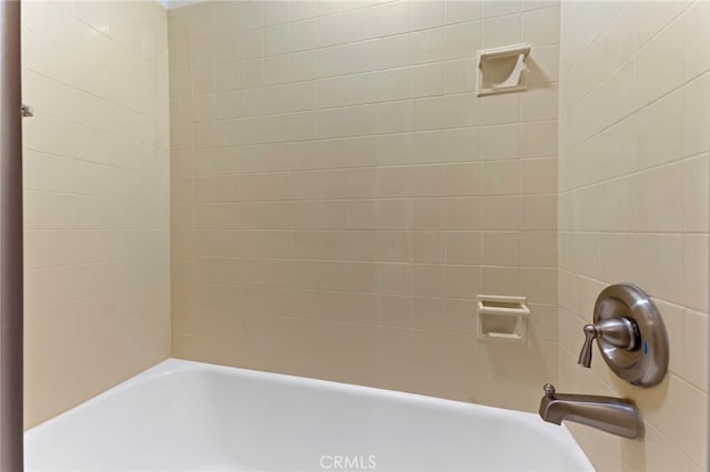 bathroom with tiled shower / bath combo