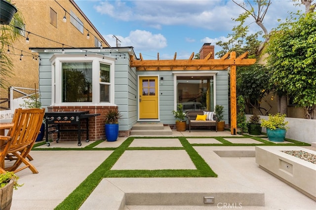 rear view of property with an outdoor fire pit and a patio area