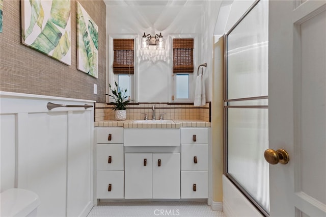 full bathroom with vanity, bath / shower combo with glass door, and toilet