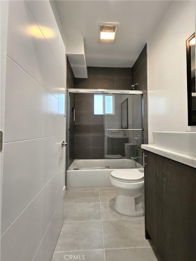 full bathroom featuring enclosed tub / shower combo, vanity, toilet, and tile patterned floors