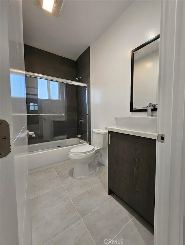 full bathroom featuring enclosed tub / shower combo, vanity, toilet, and tile patterned floors