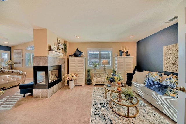 carpeted living room featuring a tile fireplace and a healthy amount of sunlight