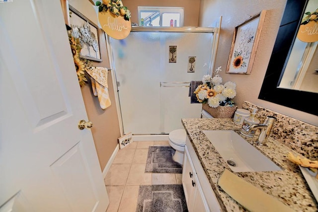 bathroom with toilet, vanity, tile patterned floors, and a shower with shower door