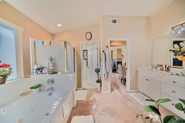 bathroom with vanity, lofted ceiling, and independent shower and bath