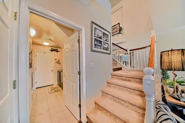 stairway with washer / dryer and tile patterned floors