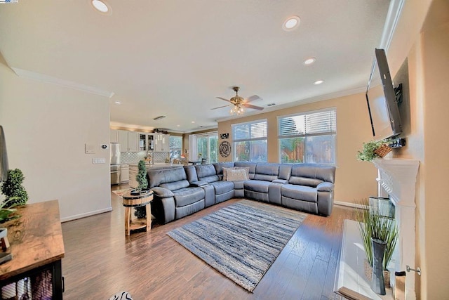 living room with ornamental molding, wood-type flooring, and ceiling fan