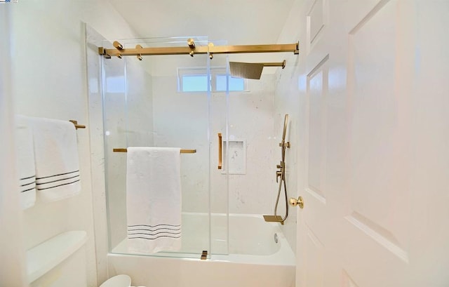 bathroom featuring toilet and combined bath / shower with glass door