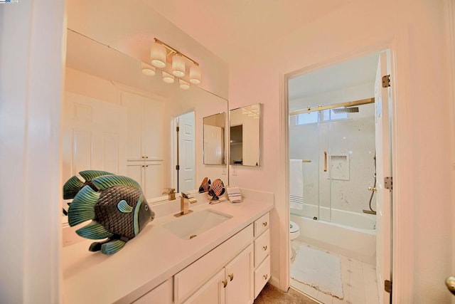 full bathroom with vanity, toilet, and combined bath / shower with glass door