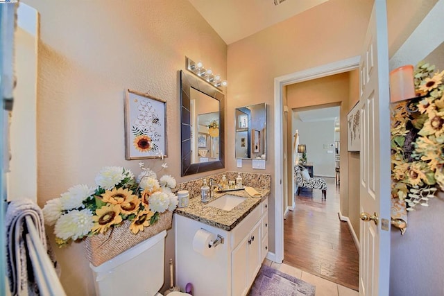 bathroom featuring vanity, tile patterned flooring, and toilet