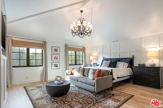 bedroom with high vaulted ceiling, a notable chandelier, and light hardwood / wood-style floors