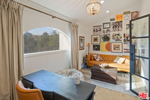 living area with hardwood / wood-style flooring, lofted ceiling, and a notable chandelier