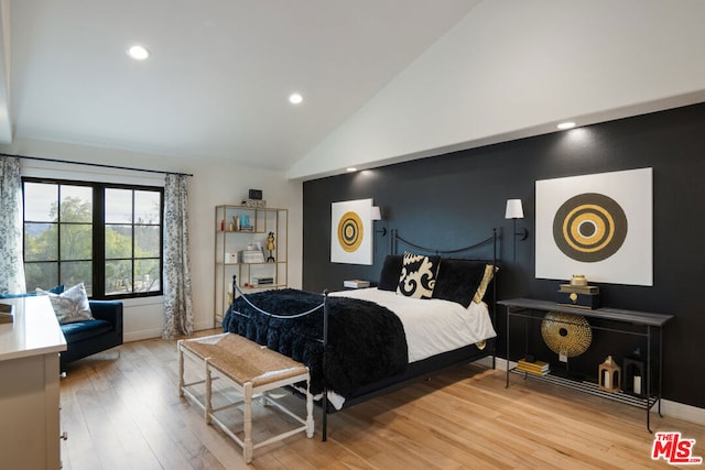 bedroom with wood-type flooring and high vaulted ceiling