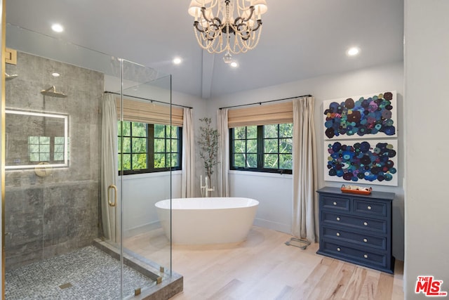 bathroom with hardwood / wood-style flooring, lofted ceiling, separate shower and tub, and a notable chandelier