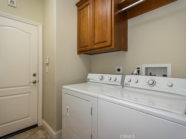 laundry area with cabinets, light tile patterned floors, and washing machine and clothes dryer