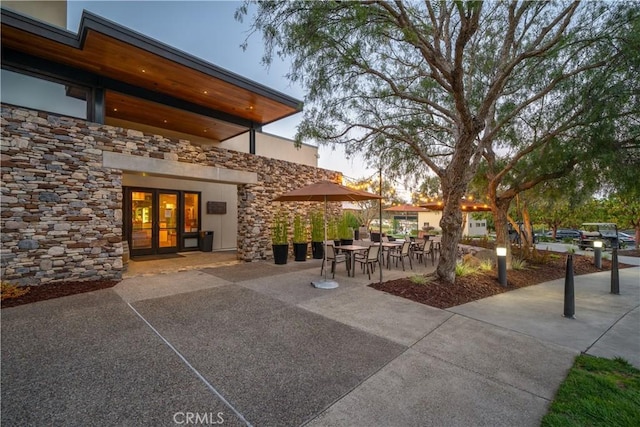 patio terrace at dusk featuring french doors