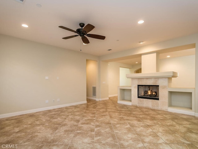 unfurnished living room featuring a tile fireplace and ceiling fan