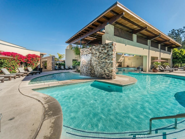 view of swimming pool with a patio and pool water feature