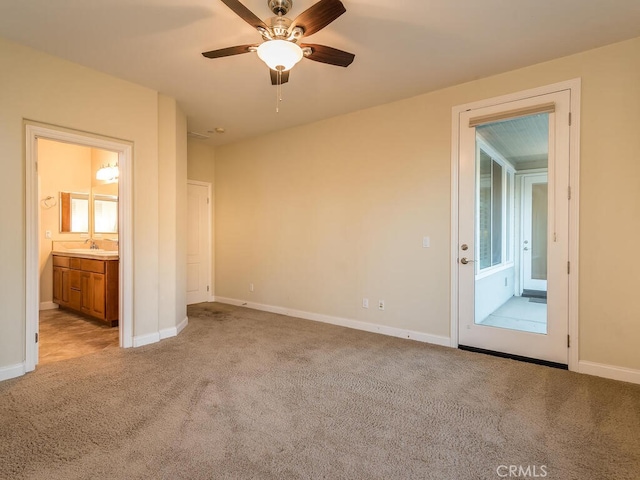 interior space with sink, light colored carpet, and ceiling fan