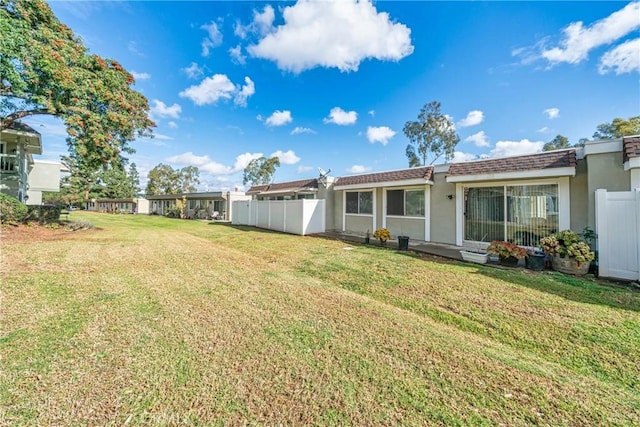 rear view of house featuring a lawn