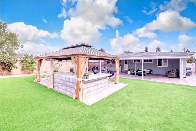 rear view of property featuring a gazebo, an outdoor hangout area, a patio, and a lawn